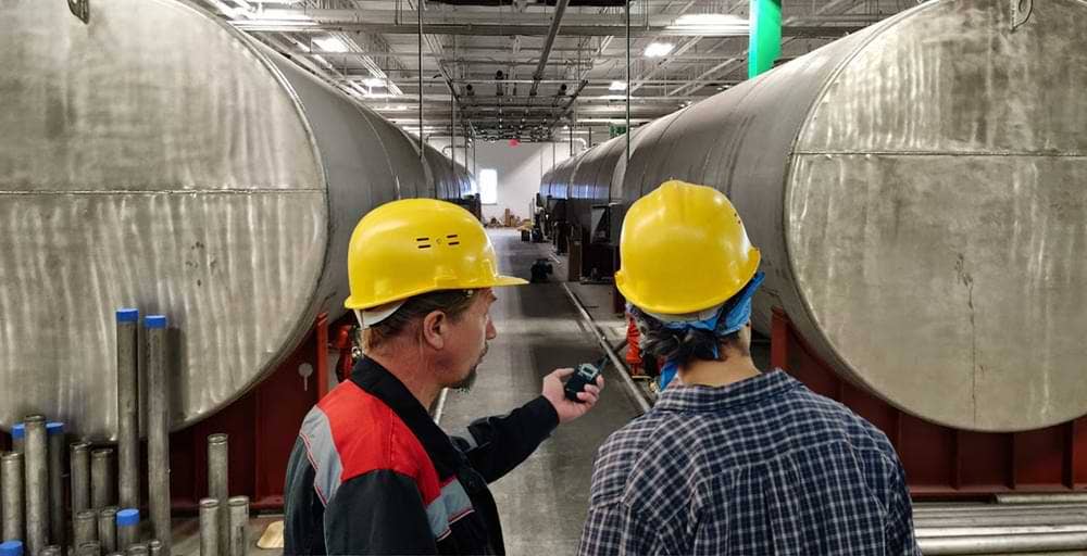 Workers in front of Raw Materials Tanks